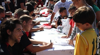 CSUEB soccer players greeting children and signing autographs.